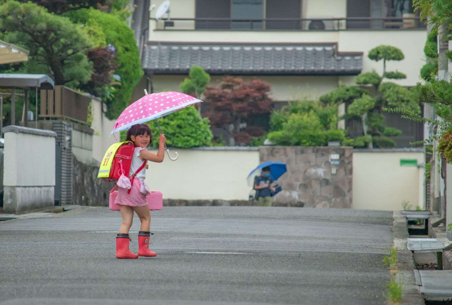 ピンクの傘をさす新一年生