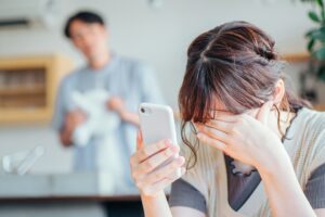 スマホを見て落ち込む女性と心配する男性