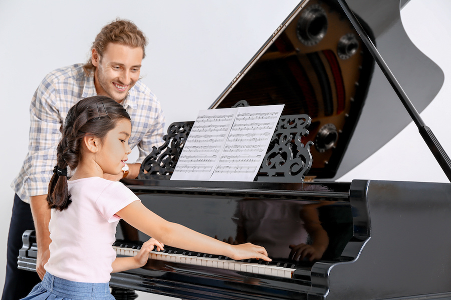 ピアノの先生が子供に教えている写真