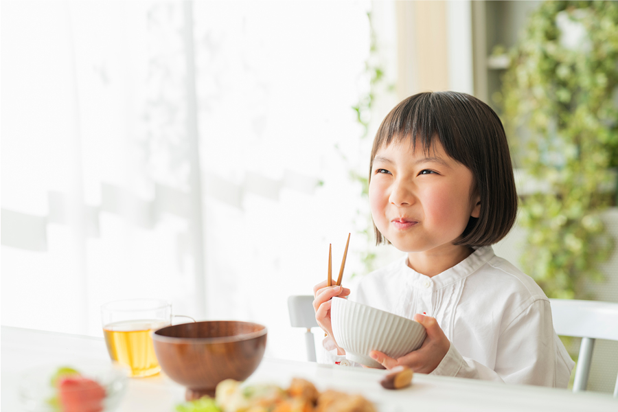 女の子がごはんをほうばる写真