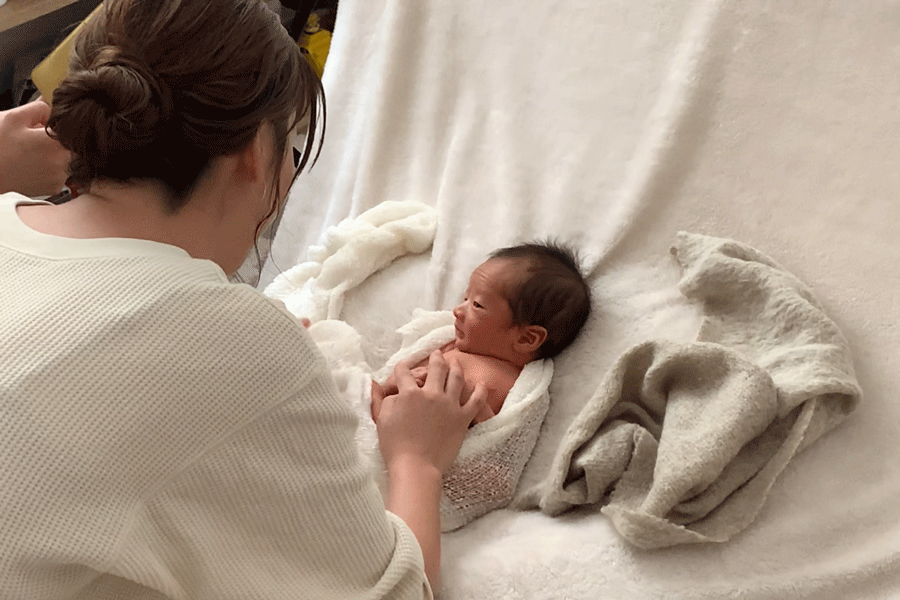 新生児をおくるみに包む様子