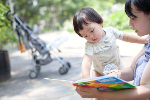 赤ちゃんに絵本を読むママ