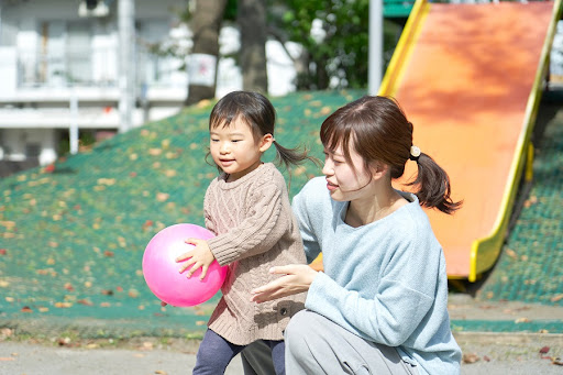 秋の公園で遊ぶ親子