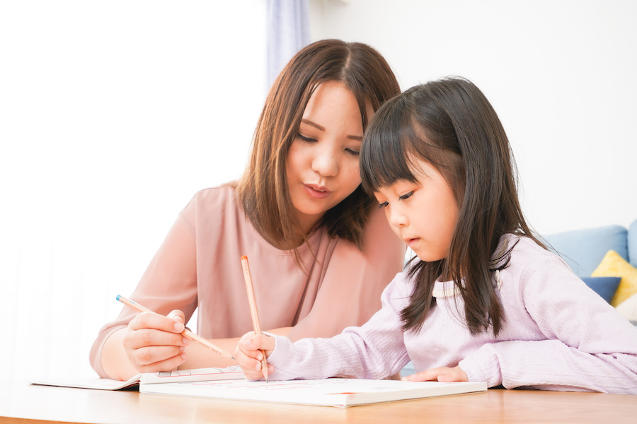 お母さんと一緒にお勉強をする小さな女の子
