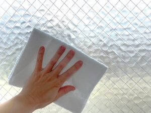 窓を雑巾で掃除する手元